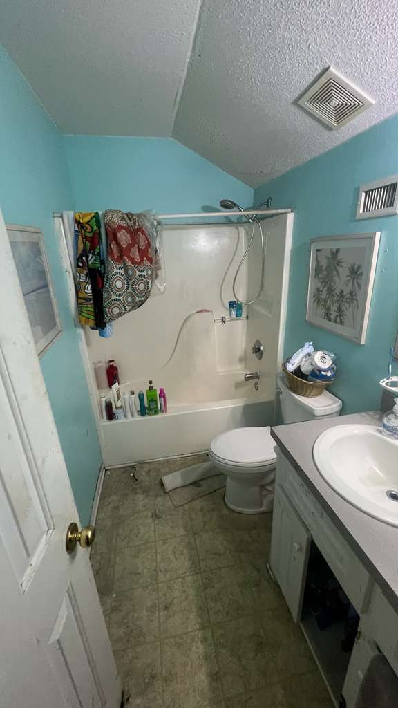 Original bathroom before remodel — dated teal walls, old fiberglass tub combo, worn tile floor — Charleston SC