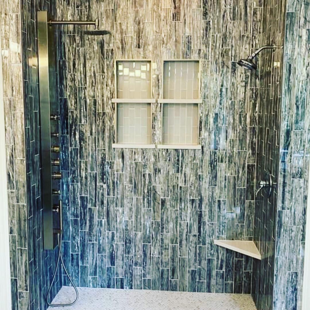 Floor-to-ceiling teal iridescent tile spa shower with dual rain-heads, body spray panel and pebble floor — Charleston SC