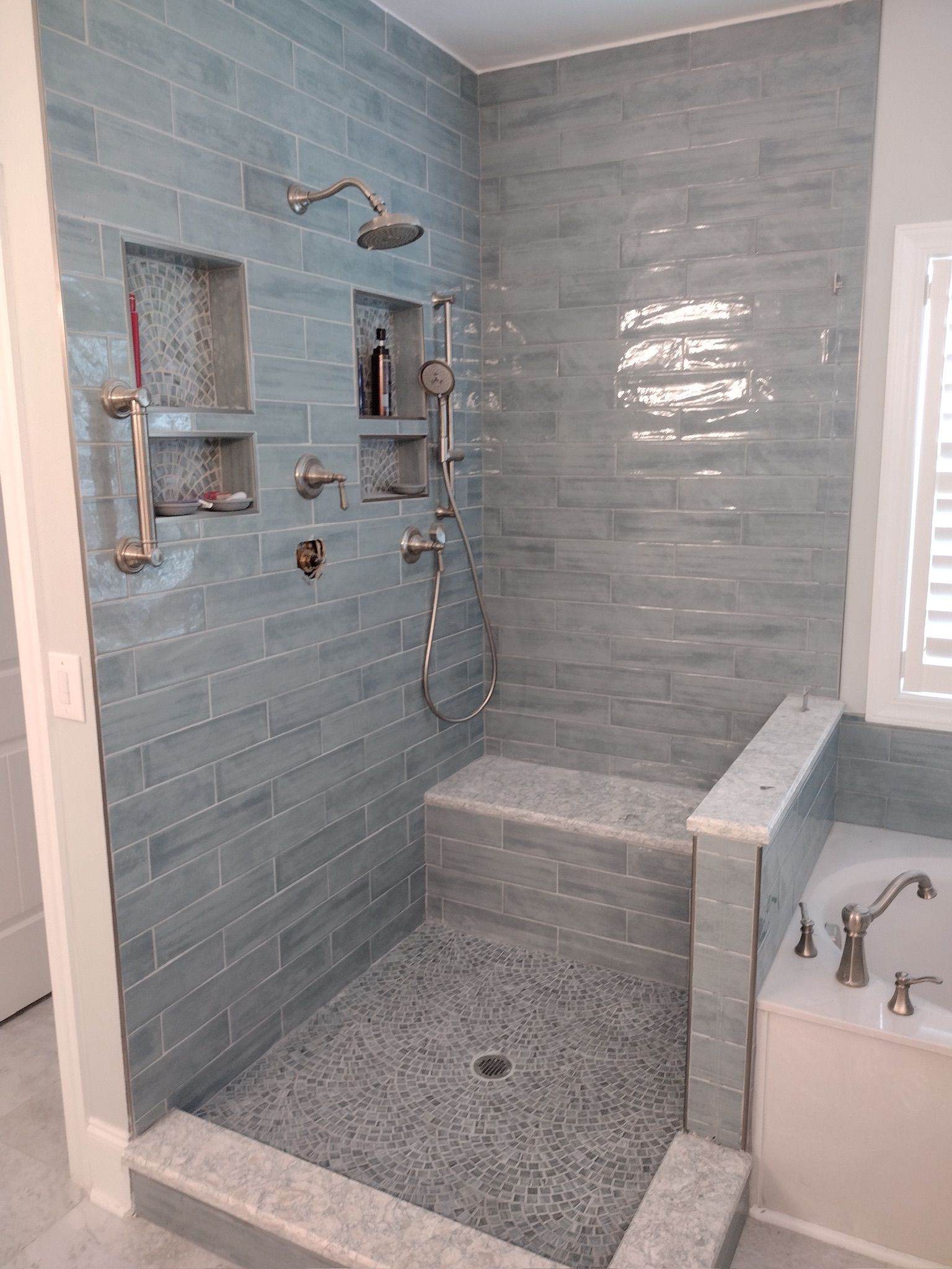 Seafoam walk-in shower with mosaic medallion drain, marble bench, dual shower heads and multiple niches — Charleston SC